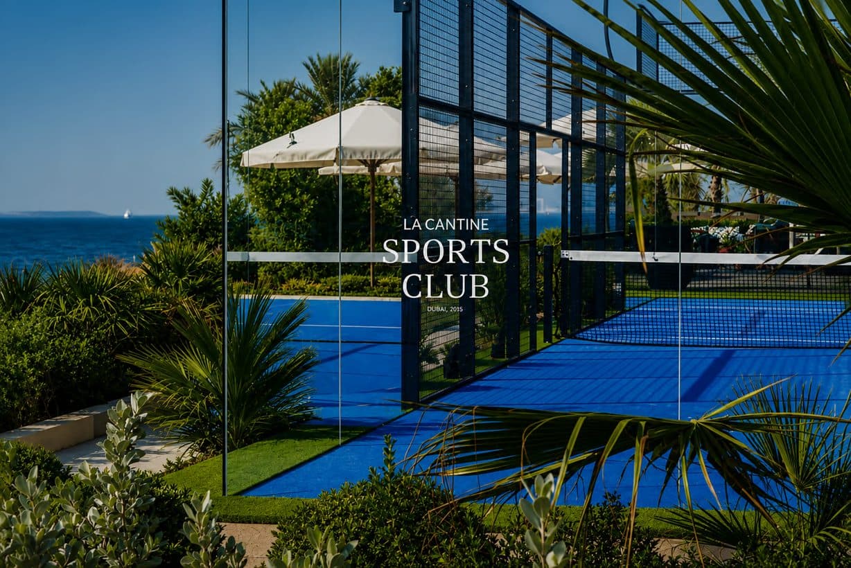 The blue padel court at La Cantine Sports Club beside the Arabian Gulf